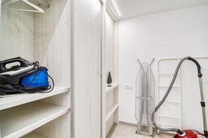 A laundry room with a blue appliance, a metal drying rack, and a vacuum cleaner. - GRAN RESERVA MIMOSES ATIC B (Empuriabrava)