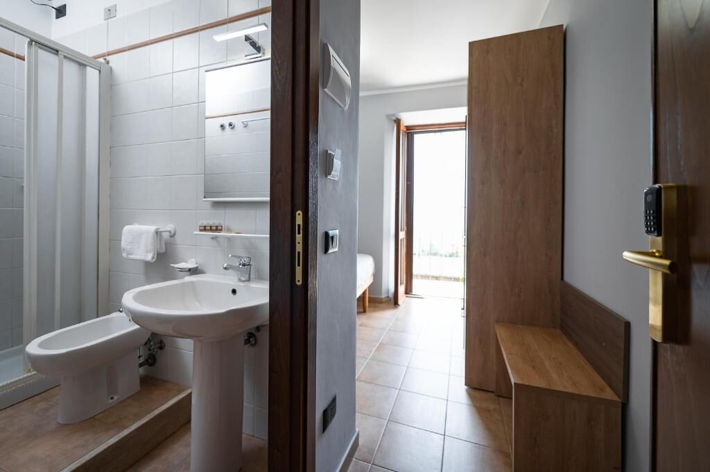 A modern bathroom with a bidet, sink, and toilet.