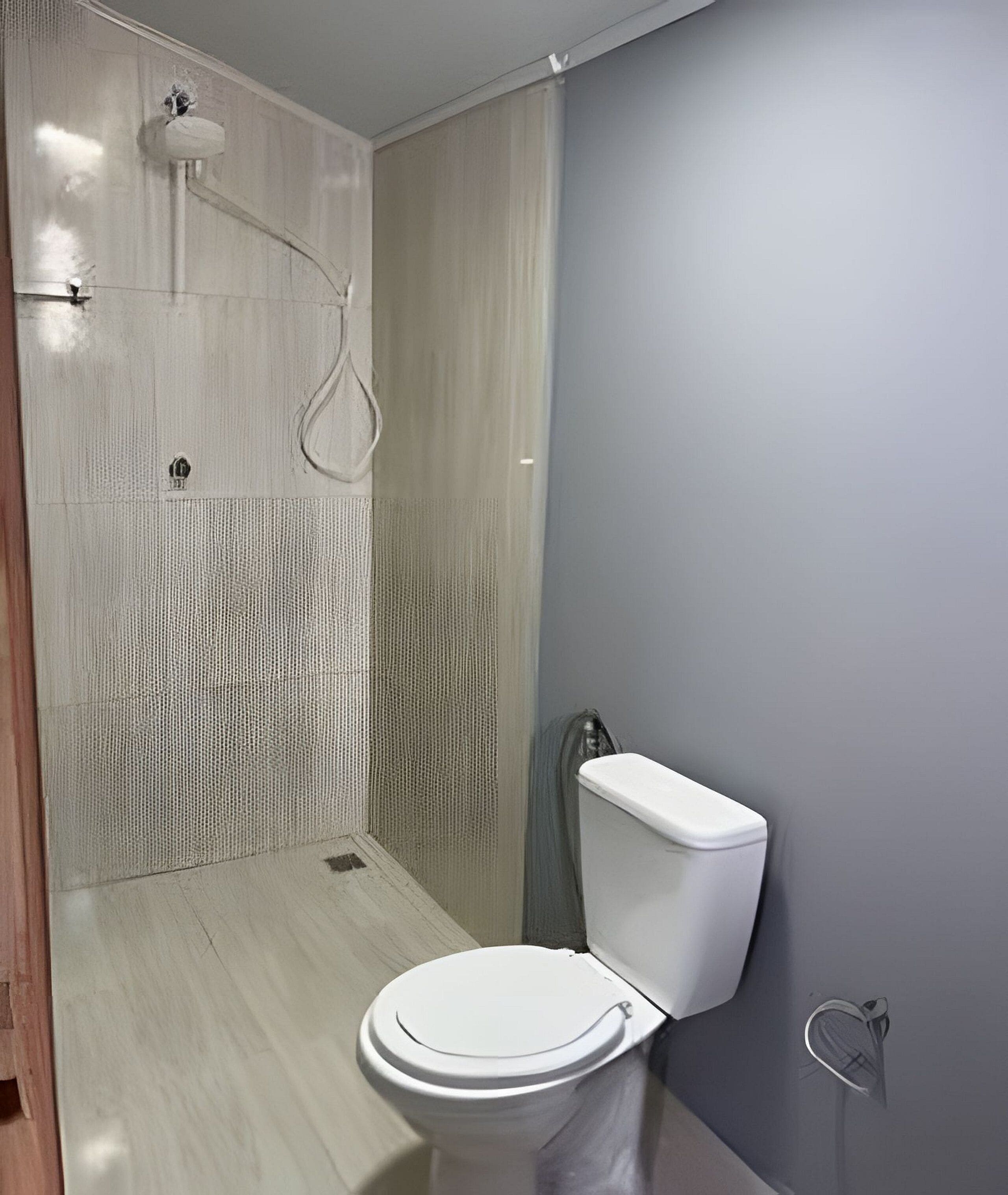 Un baño moderno con cabina de ducha, inodoro y lavamanos.