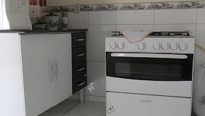 A kitchen with white cabinets, a white oven, and a black range hood.