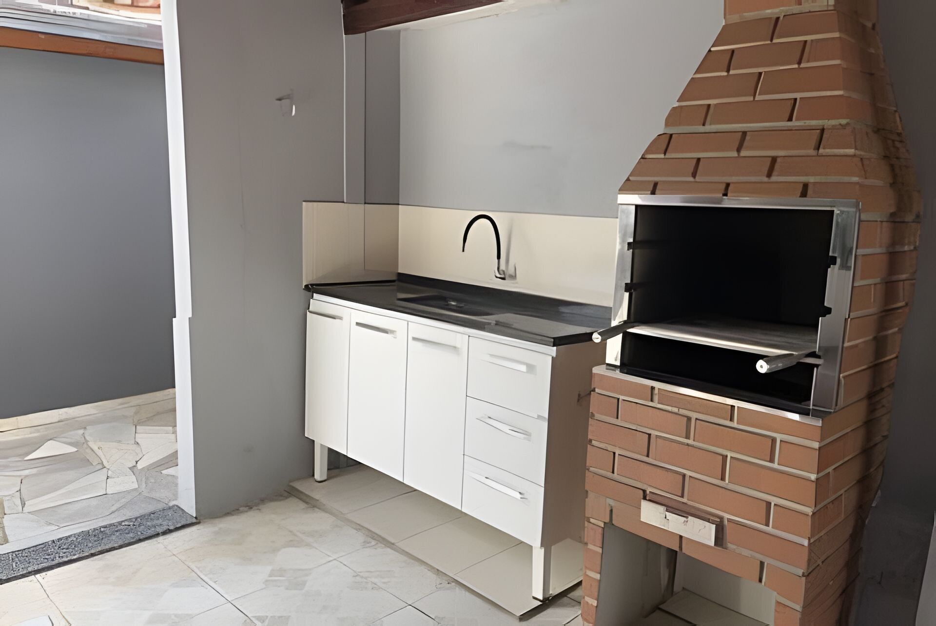 Una cocina compacta con una parrilla integrada y un lavamanos pequeño.