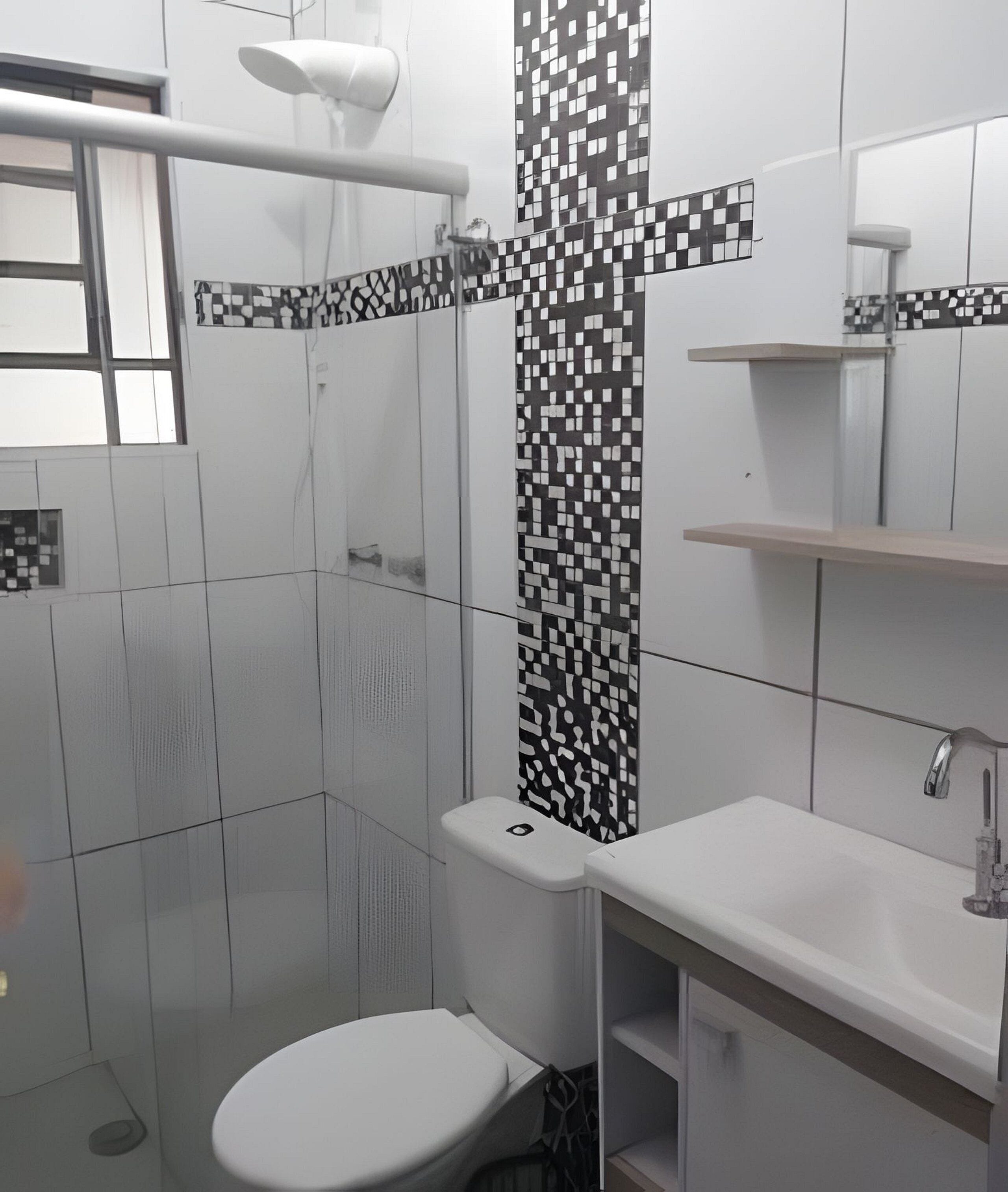 A bathroom with a toilet, a sink, and a shower area.
