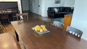Un comedor con una mesa de madera, sillas y un frutero.