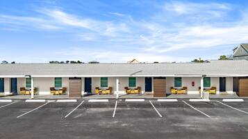 Il s'agit d'un motel doté de nombreuses chambres, chacune ayant une porte et une fenêtre. Un parking se trouve devant le motel.