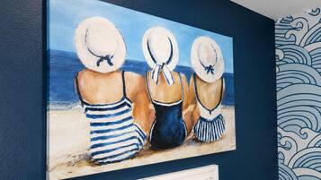 A painting of three figures in beach attire on a wall.