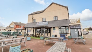 A building with a sign for 'WENDOVER BAR & GRILL' and outdoor seating with picnic tables. - The Wendover (Abergele)