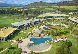 Un resort con varias edificaciones, una gran piscina y un campo de golf.