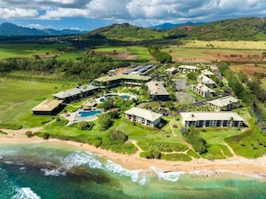 A resort with multiple buildings, a beach, and a golf course.
