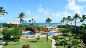 Un resort con piscina, palmeras y vista al océano.