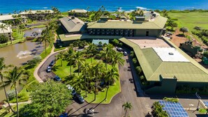 Un resort con varias edificaciones, un área de estacionamiento y vista al océano.