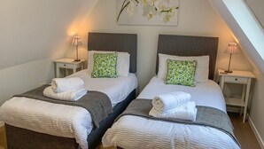 A twin room with two beds, each with a nightstand and a lamp. - The Cottage (Salisbury)