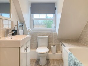 A modern bathroom with a toilet, sink, and bathtub. - The Cottage (Salisbury)