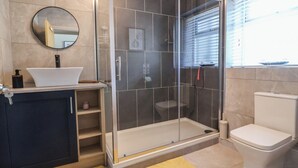 Une salle de bain moderne avec une douche à parois de verre, un lavabo blanc et des toilettes.