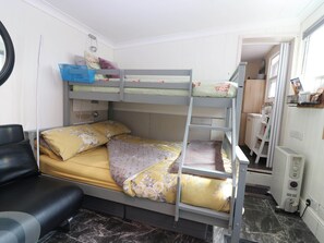 A bunk bed with a desk and chair, a radiator, and a window. - The Cabin (Kirkcaldy)