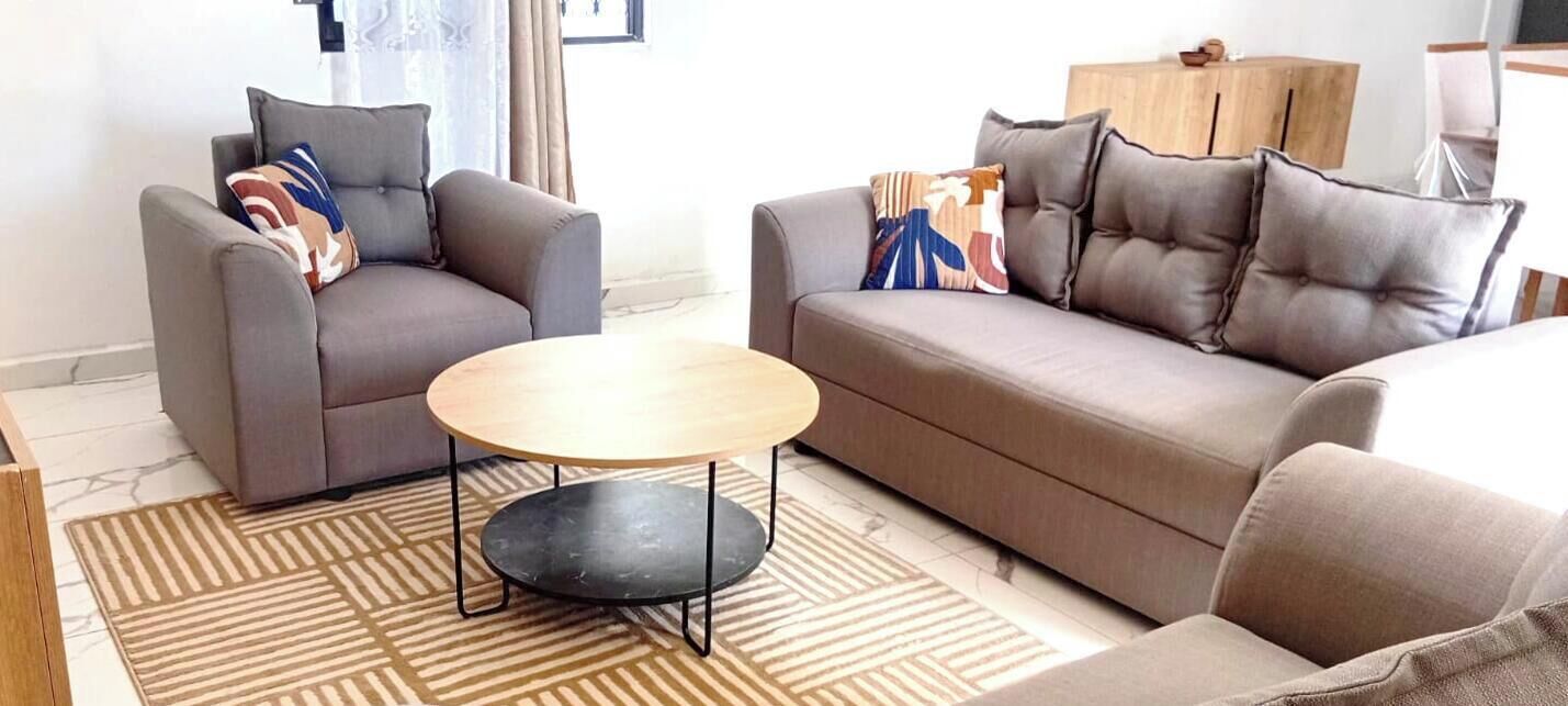 A living room with two sofas, a round coffee table, and patterned rugs.