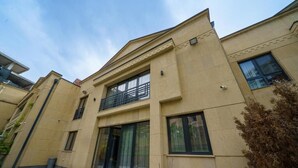 Ein Gebäude mit flacher Fassade, großen Fenstern und einem Balkon.
