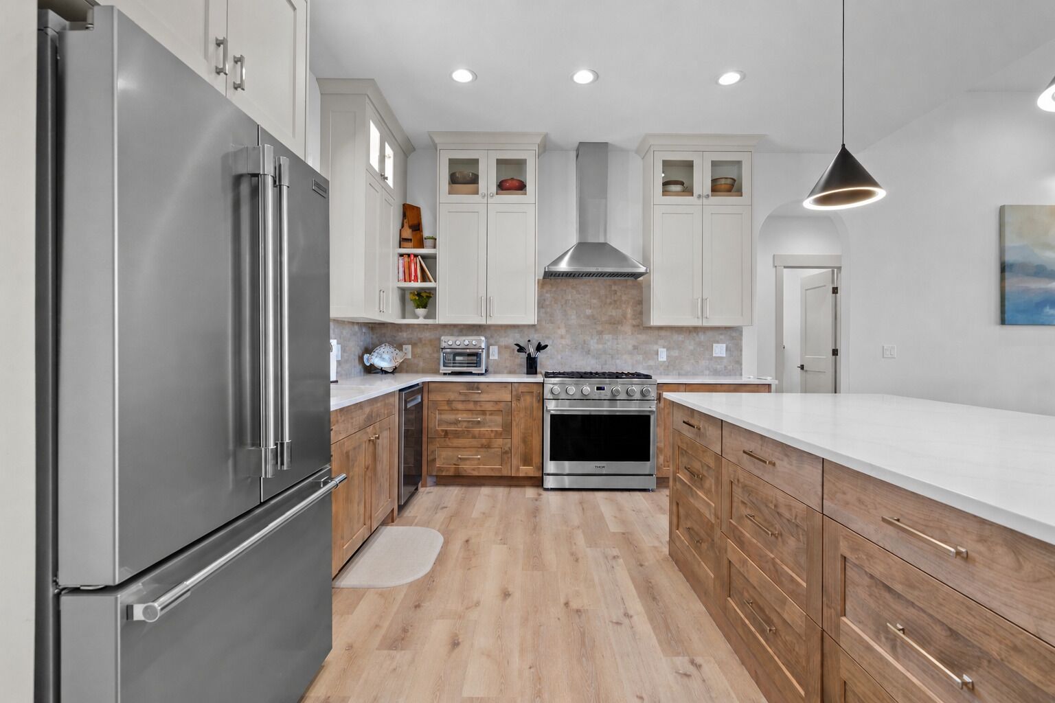 Una cocina moderna con electrodomésticos de acero inoxidable, armarios de madera y una isla central.