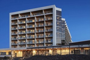 Ein modernes Hotel mit mehreren Etagen, Balkonen und einer überdachten Eingangszone.