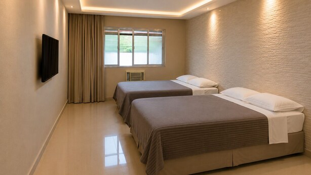 Una habitación de hotel con dos camas, un televisor en la pared y una ventana con cortinas.