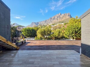 Eine Dachterrasse mit Blick auf einen Berg und Wohnhäuser.