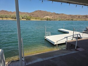 Un muelle que se adentra en el agua, con montañas al fondo.