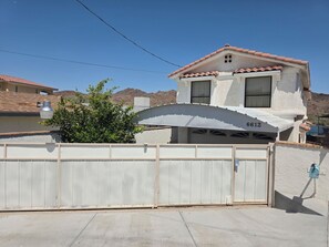 A two-story house with a white exterior, a red-tiled roof, and a garage number 6612. - Parker Strip House Riverfront, Dock, Patio & view!  2-bedroom house with AC/ SPA (Parker)
