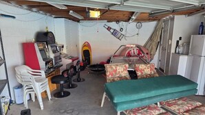 A compact room with a bed, a small desk, and a surfboard. - Parker Strip House Riverfront, Dock, Patio & view!  2-bedroom house with AC/ SPA (Parker)