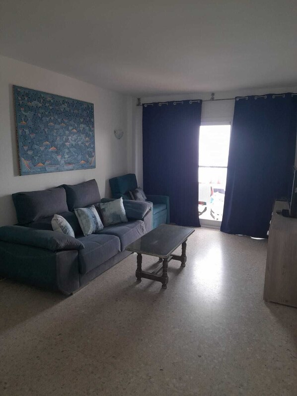 Ein Wohnzimmer mit einer Couch, einem Couchtisch und einem Bild an der Wand.
