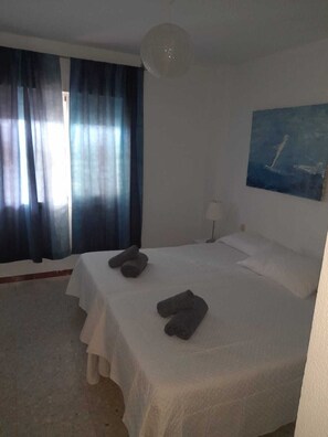 A hotel room with a bed, a painting on the wall, and a window with curtains. - Wonderful views (Nerja)