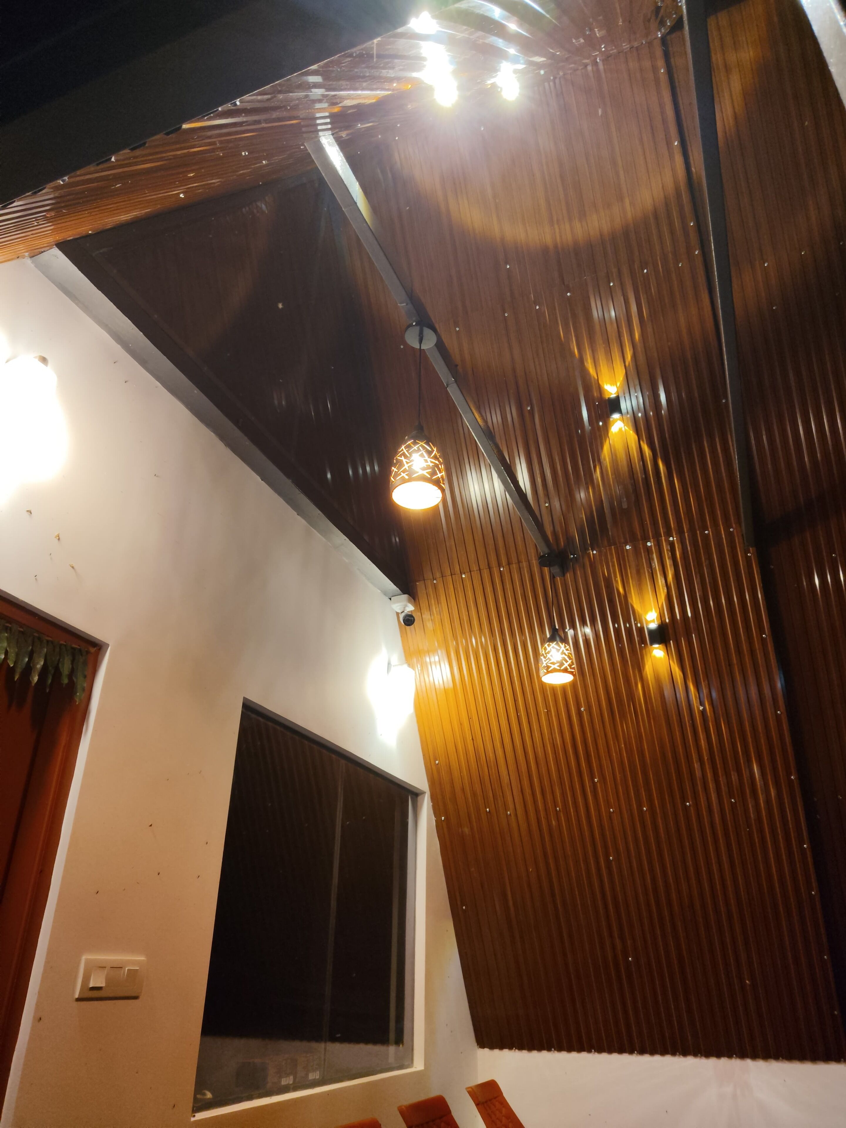 Une pièce avec un plafond en pente, une grande fenêtre et un luminaire.