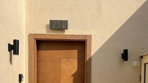 A wooden door with a handle and a small sign above it.