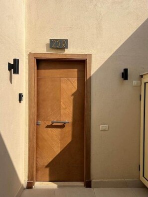 A wooden door with a handle and a small sign above it.