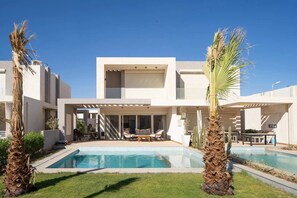 A modern two-story building with a swimming pool, outdoor seating, and palm trees. - Casa Maraya with private pool I Nesty Hospitality (Second Hurghada)