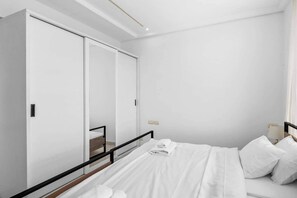 Ein Schlafzimmer mit einem Bett, einem Kleiderschrank und einem Spiegel.