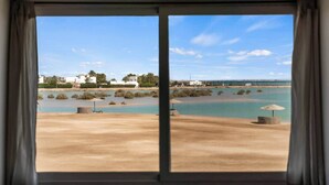 A view through a window with a beach and water body in the background. - The Sandy Feet. Part II - Nesty Hospitality (Hurghada)