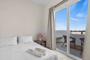 A hotel room with a bed, a nightstand with a lamp, and a view of the outside balcony. - The Sandy Feet. Part II - Nesty Hospitality (Hurghada)