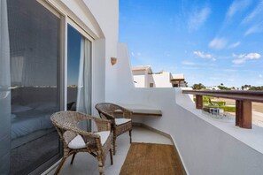A balcony with two wicker chairs, a glass door, and a view of the neighborhood. - The Sandy Feet. Part II - Nesty Hospitality (Hurghada)