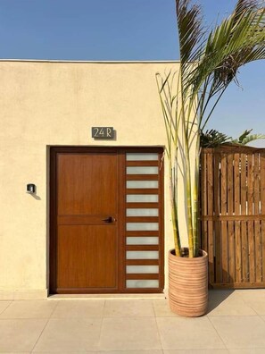 Eine Holztür mit Schild, einem Blumentopf und einem Holzzaun.