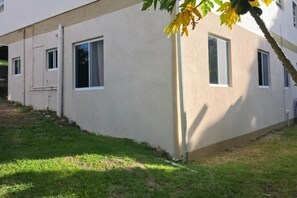 A building with multiple windows and a grassy area in front. - Modern 2-bedroom/1-bath apartment in La Tante perfect for relaxing stays (Bellevue)