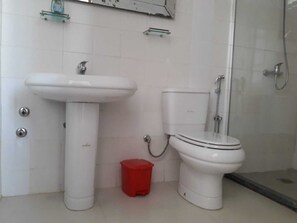 Ein Badezimmer mit weißem Waschbecken, WC und Dusche.