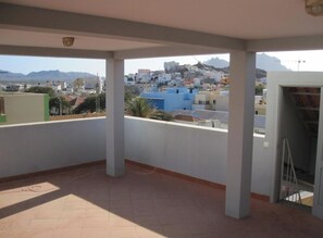 A balcony with a view of a cityscape and mountains. - Enjoyable 1-bedroom apartment in adorable Mindelo neighborhood (Mindelo)