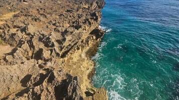 A coastal landscape with rocky terrain and clear blue waters.