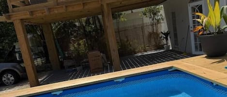 Une piscine avec une terrasse en bois et un pont en bois.