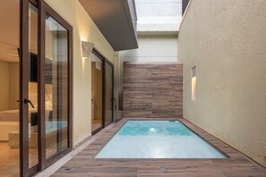 A narrow indoor pool area with a wooden floor, glass doors, and a light-colored wall. - Luxury Loft Parque de Novios-ByHuespedia (Santa Marta)