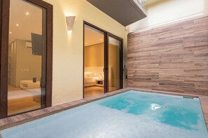 Ein moderner Poolbereich im Innenbereich mit einer Holzwand und einer Glastür zum Schlafzimmer.