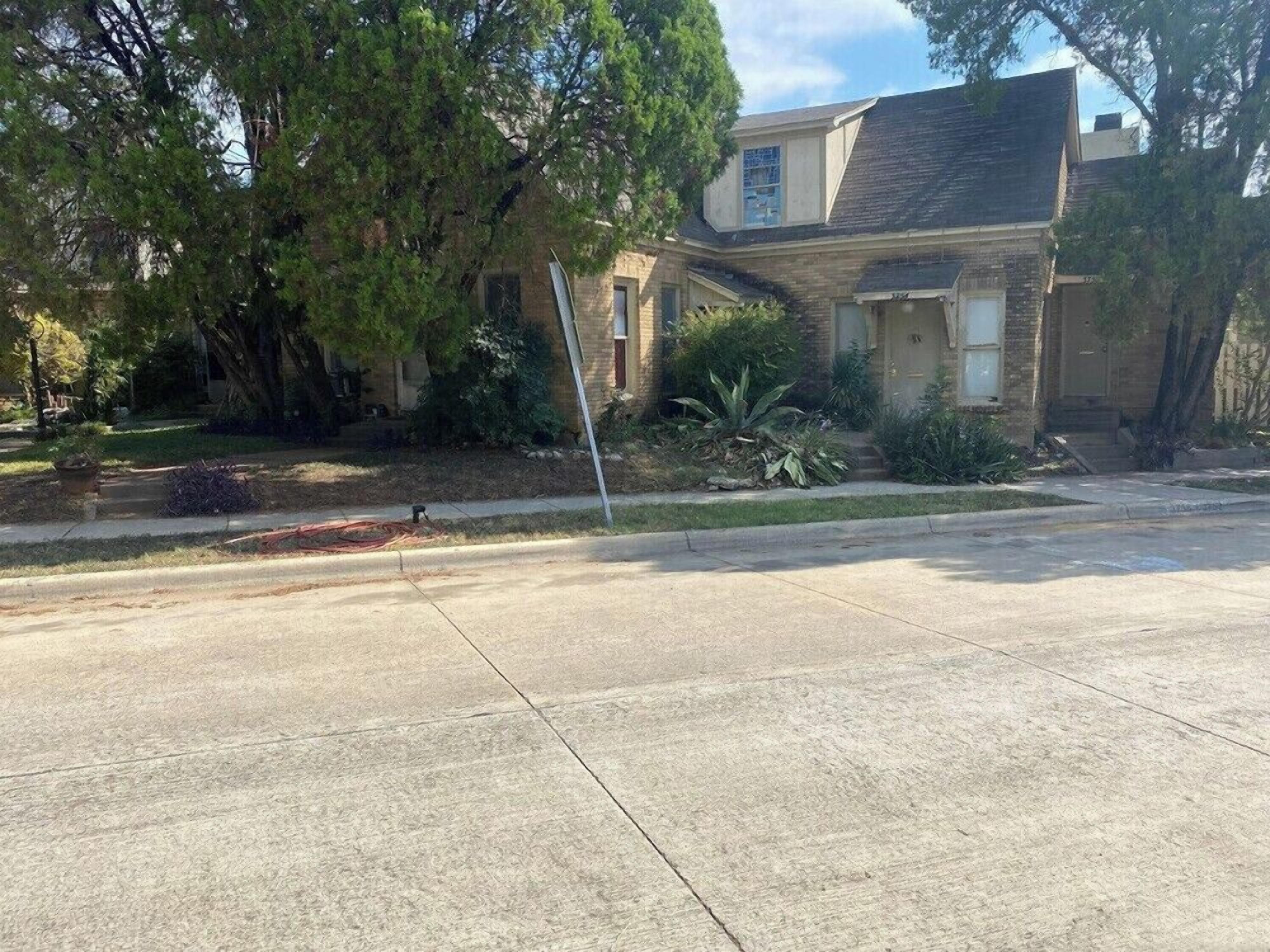 A residential house with a front yard, a driveway, and a sidewalk.