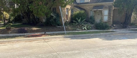 A residential house with a front yard, a driveway, and a sidewalk.
