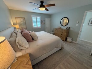 A bedroom with a bed, dresser, ceiling fan, and a window with blinds. - Perfect 2-bedroom cottage in the Village Green Community of enchanting Cape May (Cape May)
