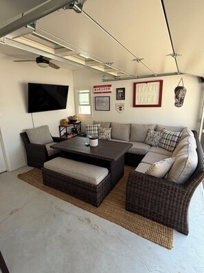 A living room with a sectional sofa, a coffee table, and a flat-screen TV mounted on the wall. - Perfect 2-bedroom cottage in the Village Green Community of enchanting Cape May (Cape May)