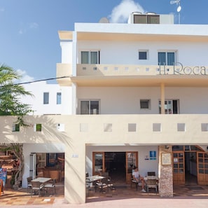 A two-story building with a sign reading 'H. Rocha' on the upper level. - Rocaplana Hostal (Formentera)